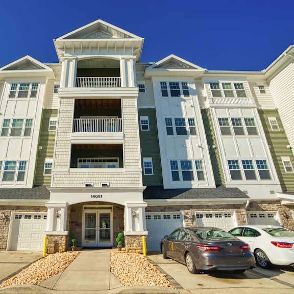 a large apartment building with cars parked in front of it