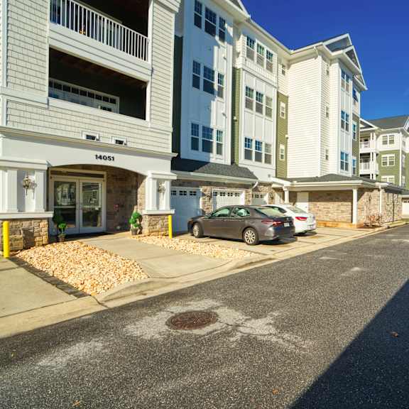 a street with white houses on either side and a car parked in front