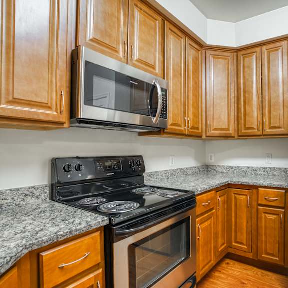 an empty kitchen with wood cabinets and stainless steel appliances