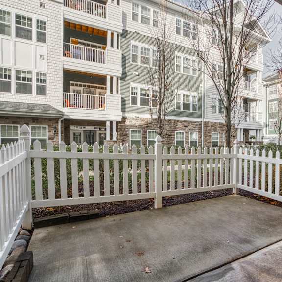 the front porch of an apartment building with a white fence