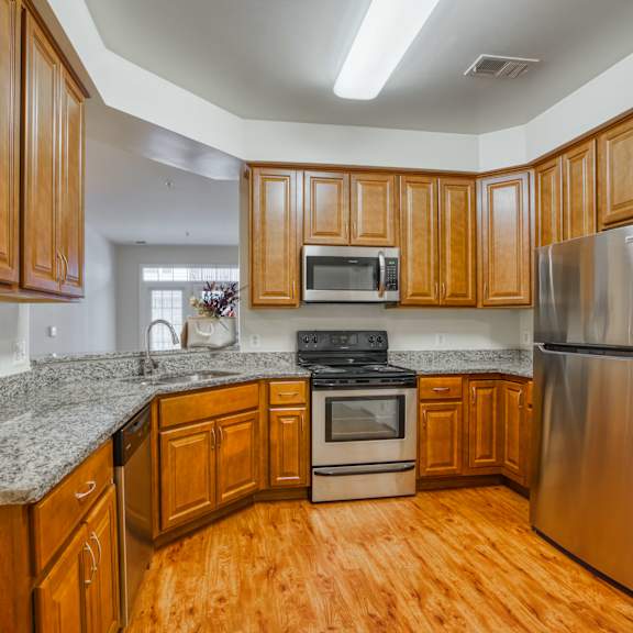 a kitchen with wooden cabinets and granite counter tops and stainless steel appliances