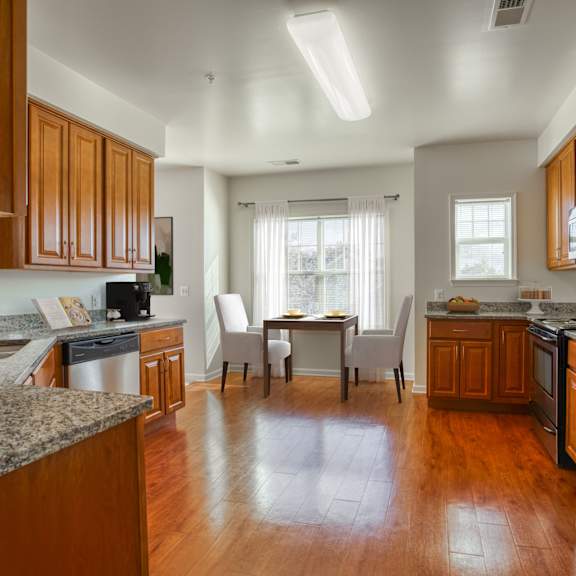 a kitchen and dining room with wood floors and stainless steel appliances