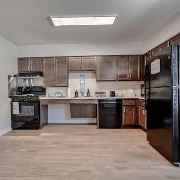 an empty kitchen with black appliances and wooden cabinets