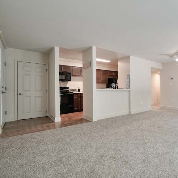 an empty living room with white walls and a ceiling fan