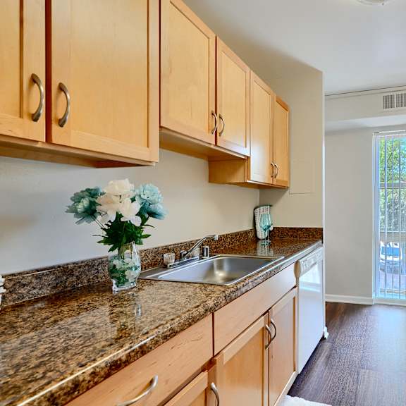 a kitchen with wooden cabinets and a granite countertop.