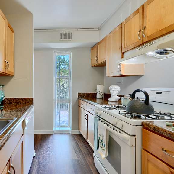 a kitchen with wooden cabinets and a white stove top oven.