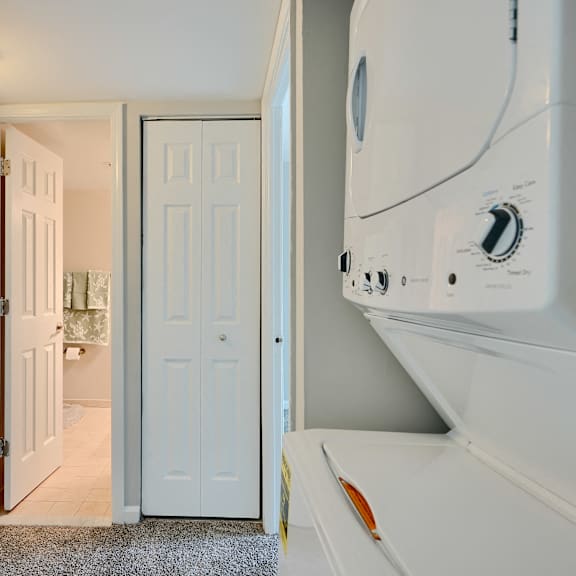 a white washing machine is in a laundry room.
