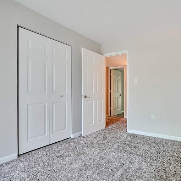 a room with a carpeted floor and two white doors.