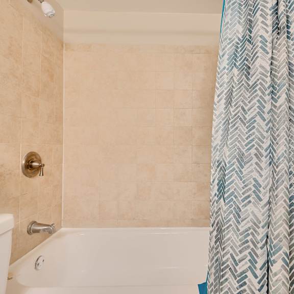 a bathroom with a white tub and a shower curtain.