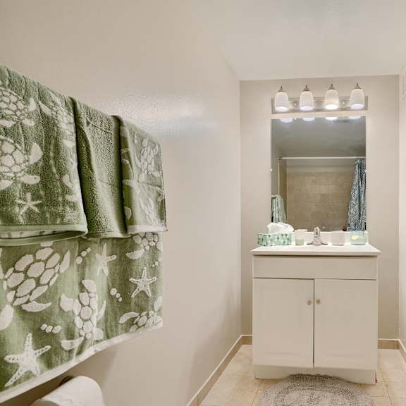 a white cabinet with a mirror above it is in a bathroom.