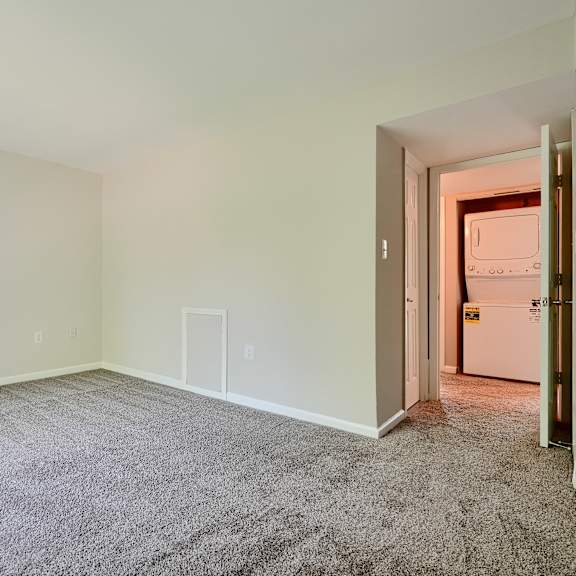 a room with a carpeted floor and a door on the right side.