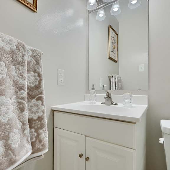 a bathroom with a floral towel hanging on the shower curtain.