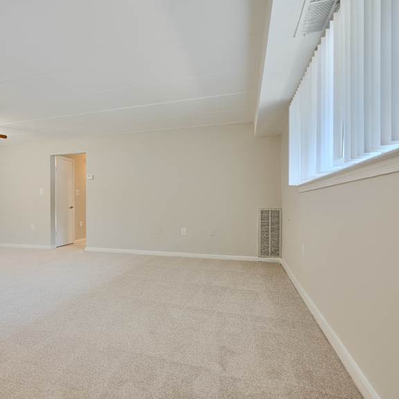 a room with a ceiling fan and carpeted floor.