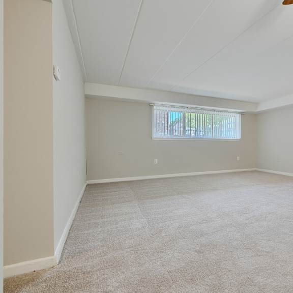a room with a carpeted floor and a window.