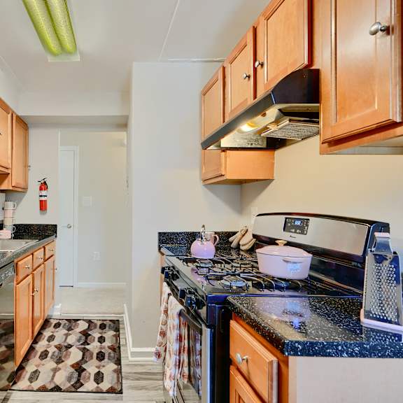 a kitchen with a black counter top and wooden cabinets.