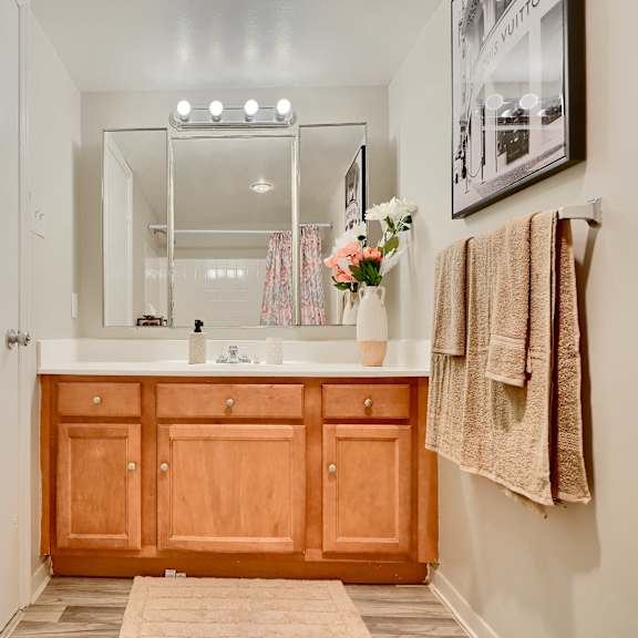 a bathroom with a wooden vanity and a mirror above it.