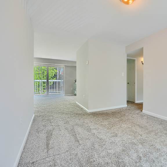 a spacious room with a carpeted floor and white walls.