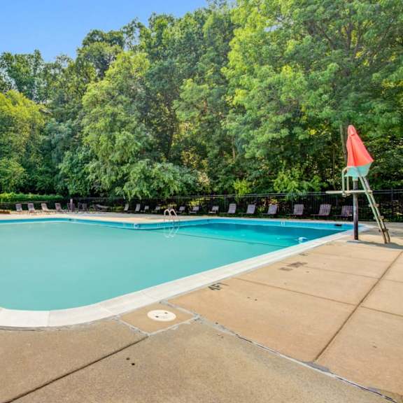a swimming pool with trees in the background