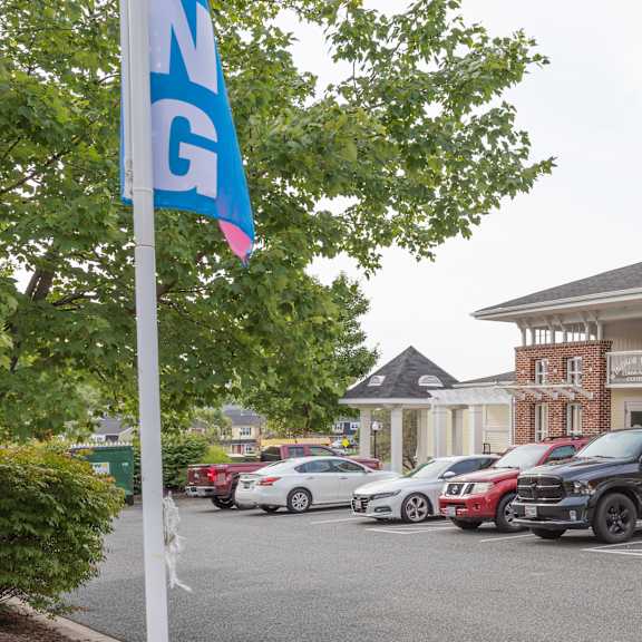a parking lot with cars and a building in the background.