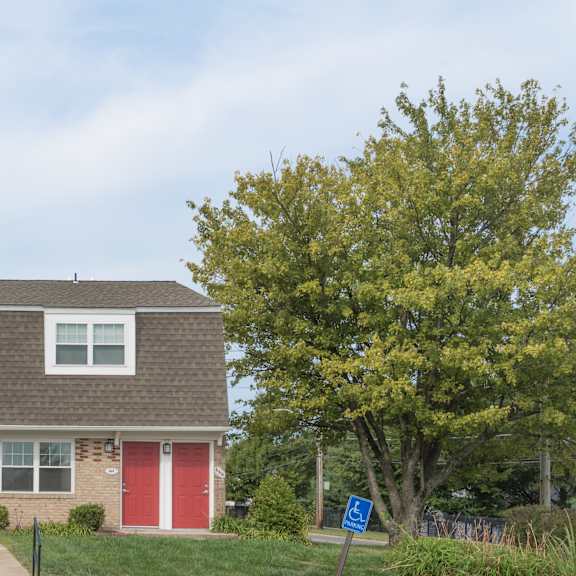 a house with a red door and a blue sign in front.