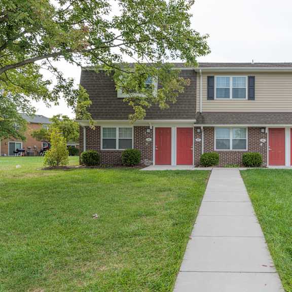 a house with a red door and a green lawn.