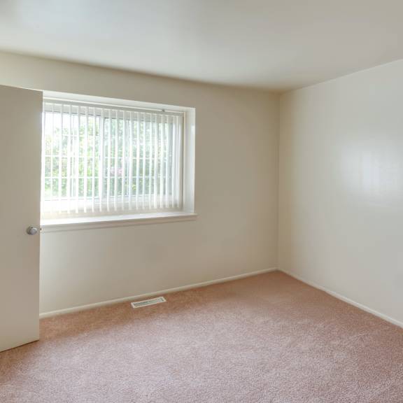 a room with a window and carpeted floor.