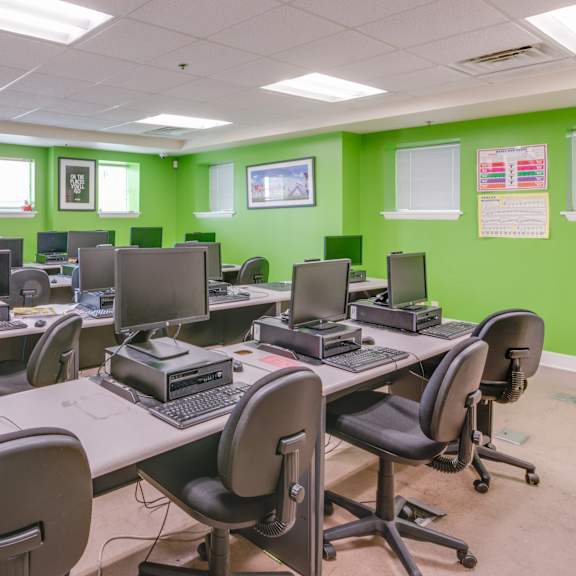 a room with green walls and multiple computer desks.