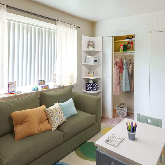 a room with a green couch and a white table with a container of pens on it.