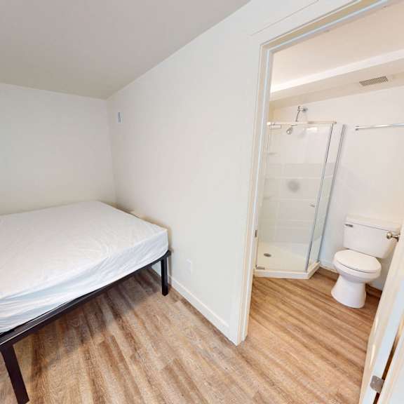 a bedroom with a bed, toilet, and sink.