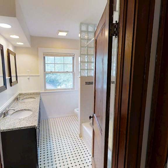 a bathroom with a sink, mirror, and tiled floor.