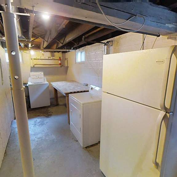 a kitchen with a refrigerator, sink, and cabinets.