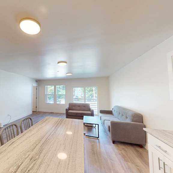 a spacious living room with a long wooden table and chairs.