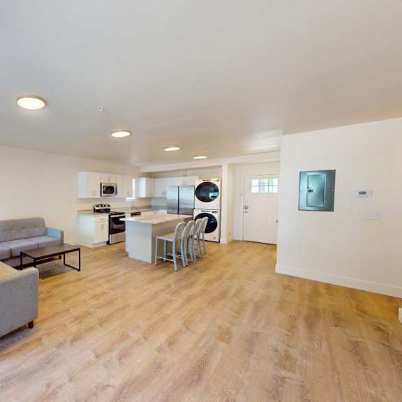 a living room with a grey couch and a wooden floor.