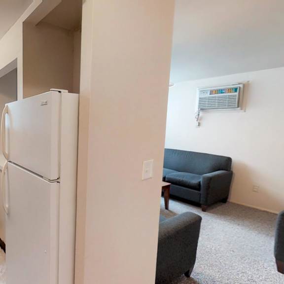 a kitchen area with a refrigerator, sink, and microwave.