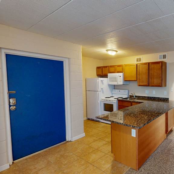 a kitchen with a blue door and white appliances.