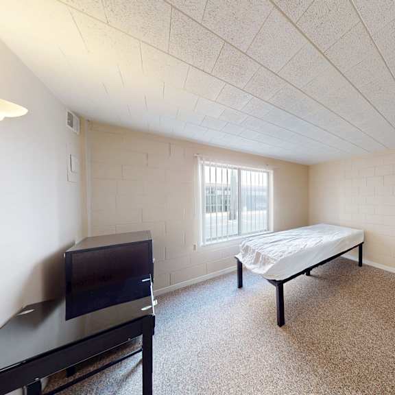 a bedroom with a bed, dresser, and television.