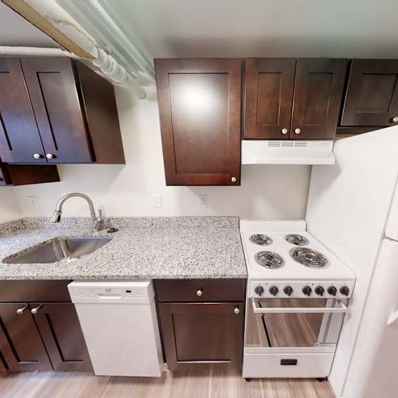 a kitchen with white appliances and brown cabinets.