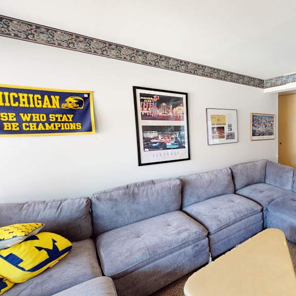 a living room with a grey couch and a yellow pillow.