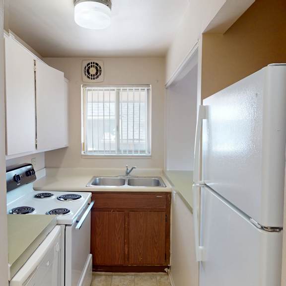 a kitchen with white appliances and wooden cabinets.