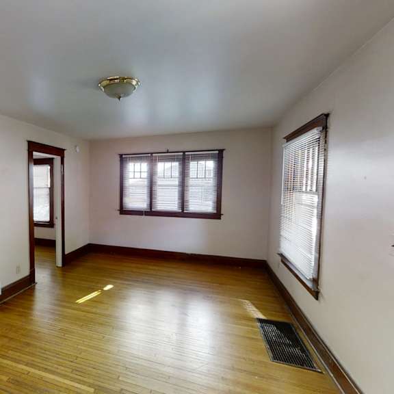 a room with wooden floors and a staircase leading to another room.
