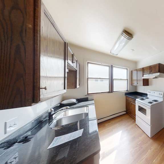 a kitchen with white appliances and wooden cabinets.