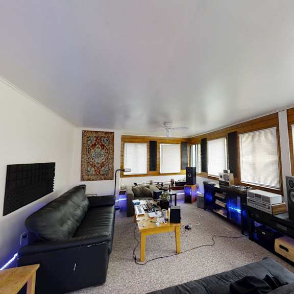 a living room with a black couch and a coffee table.