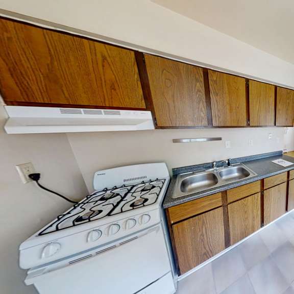 a kitchen with a white stove and wooden cabinets.