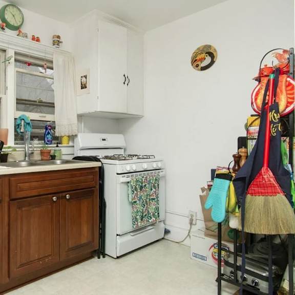 a kitchen with wooden cabinets and a white stove top oven.