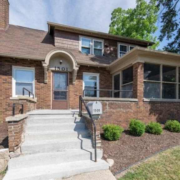 a house with a brick facade and a stone staircase leading to the front door.