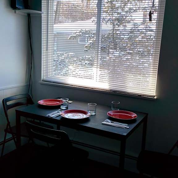 a table with two chairs and a meal set up by a window.
