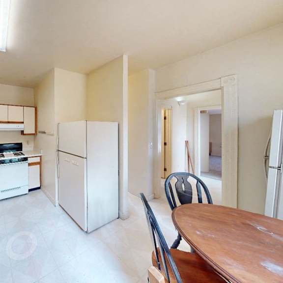 a kitchen with white cabinets and a wooden table.