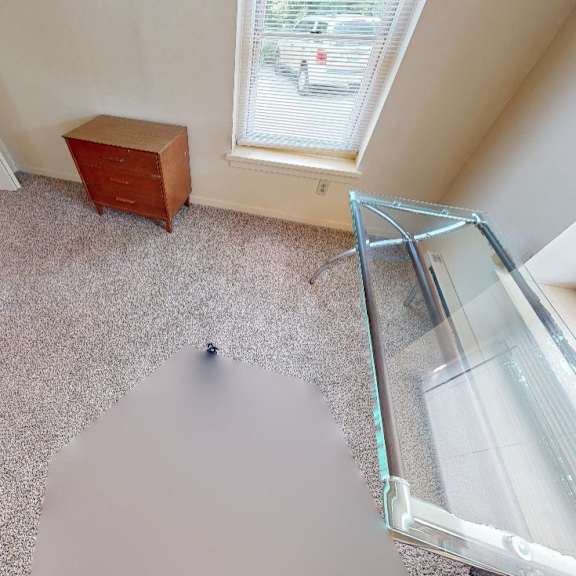 a room with a bed, a window, and a table.