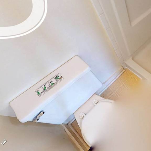 a white toilet with a white tank and a white sink in a bathroom.
