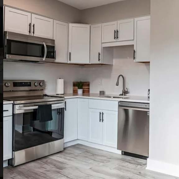 a kitchen with white cabinets and stainless steel appliances.